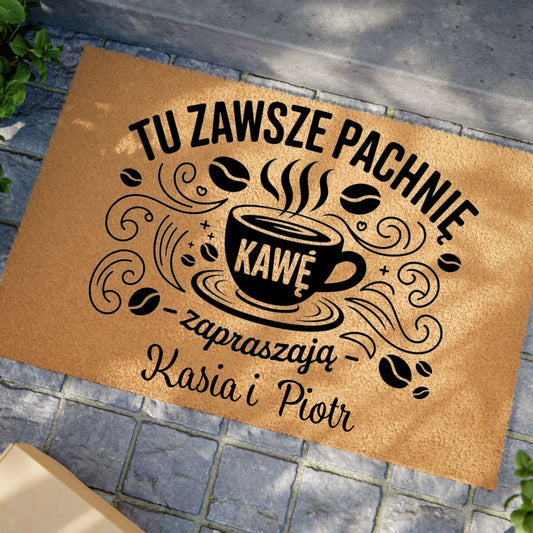 Wycieraczka z napisem „Tu zawsze pachnie kawą” z personalizowanymi imionami i grafiką filiżanki kawy.