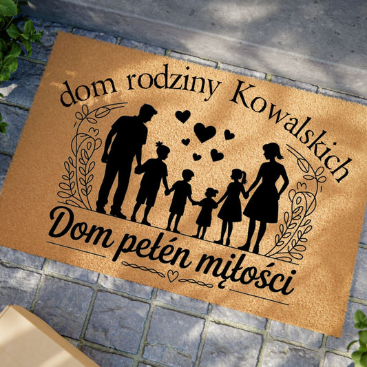 Wycieraczka z napisem „Dom pełen miłości” z personalizowanym nazwiskiem rodziny i grafiką przedstawiającą rodzinę z sercami.