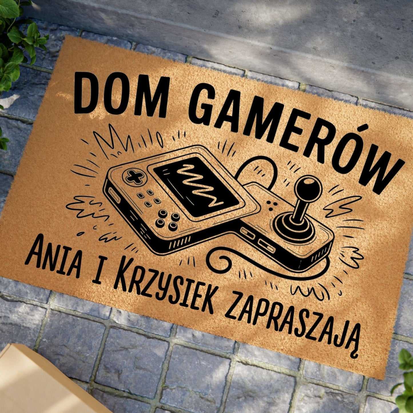Wycieraczka z napisem „Dom Gamerów” i personalizowanymi imionami, ozdobiona joystickiem retro.